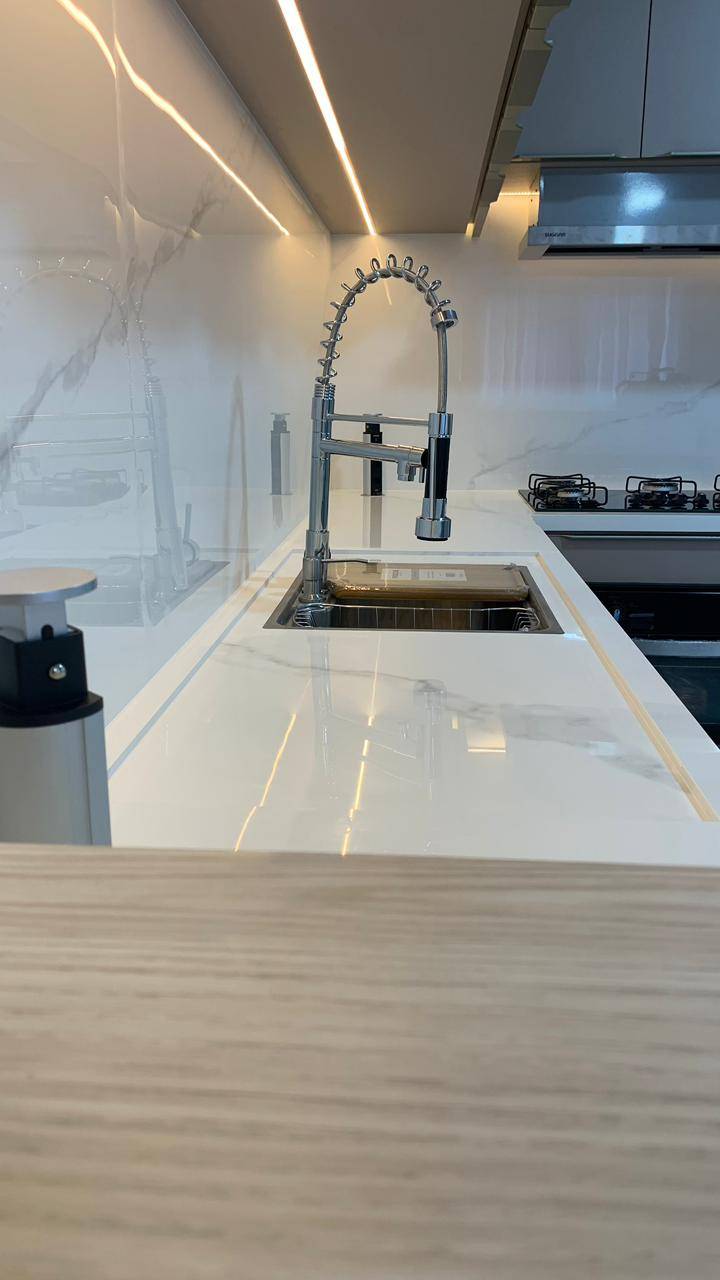 Cozinha em porcelanato cinza com armários escuros.